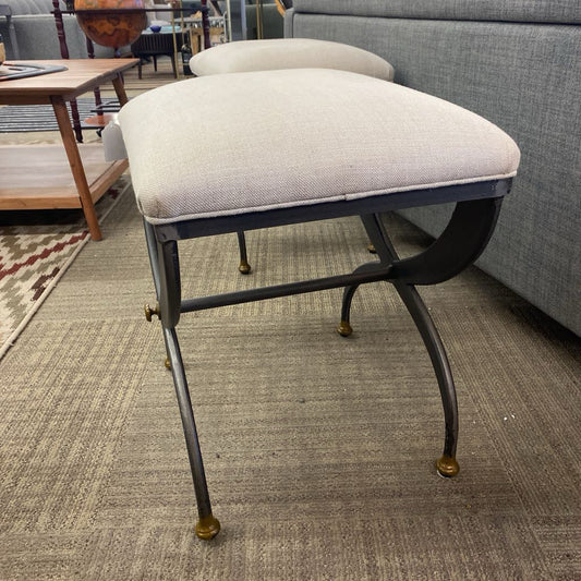 Decorative stool with a cushioned seat on a carpeted floor