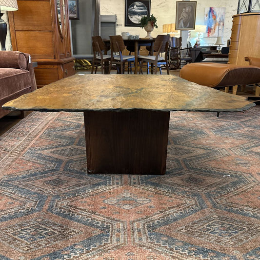 Large wooden dining table in a room with chairs and decor