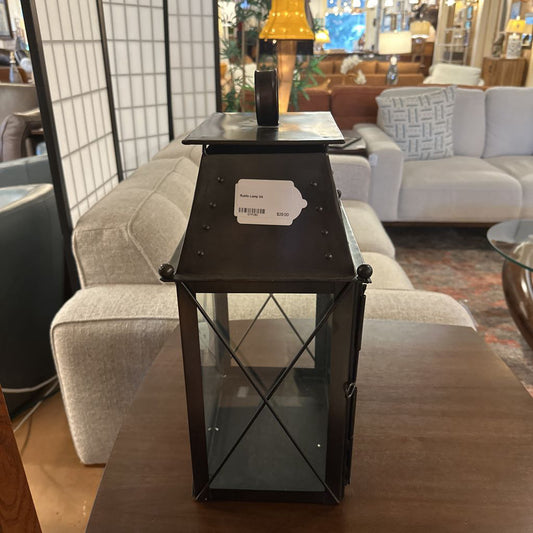 Black metal side table with a glass top in a living room setting