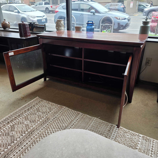 Wooden cabinet with open door on a patterned rug