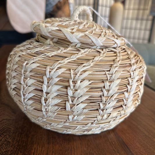 Woven basket with a lid on a wooden surface