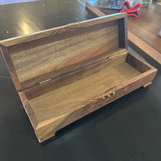 Wooden jewelry box with a gold clasp on a dark surface