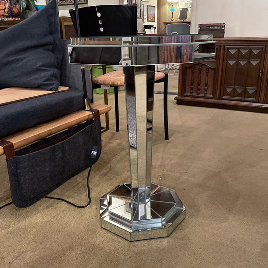 Decorative glass table with hexagonal base in a showroom setting