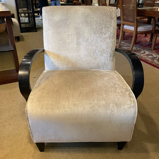 Beige armchair with black metal armrests in a room setting