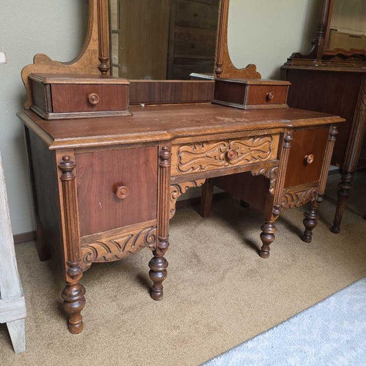 Vintage wooden vanity with mirror on a carpeted floor