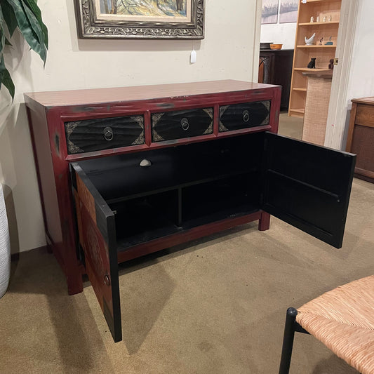 Wooden sideboard with open doors in a room setting
