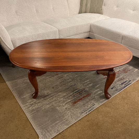 Wooden coffee table in front of a gray sofa on a textured rug