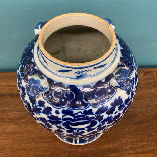 Blue and white ceramic jar with intricate patterns on a wooden surface.
