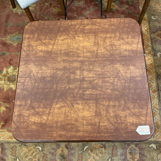Worn wooden table top on a patterned rug
