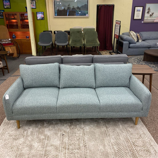 Gray sofa in a room with chairs and a table