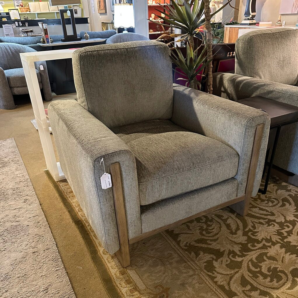 Gray armchair with wooden legs in a showroom setting