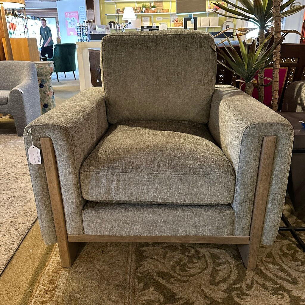 Gray armchair with wooden legs in a store setting
