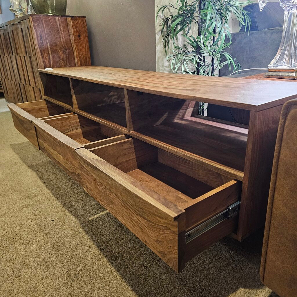 Wooden entertainment console with open drawer in a room setting