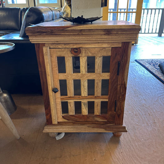 Wooden side table with glass panels in a living room setting
