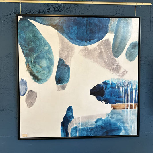 Abstract art piece with blue and gray shapes on a blue wall