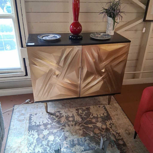Cabinet with geometric design doors in a room with a rug and window.
