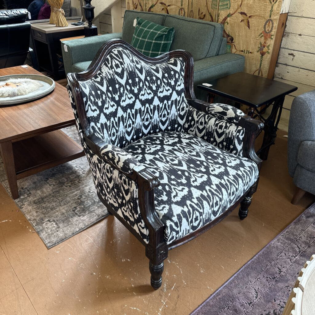 Patterned armchair in a living room setting with furniture and decor.
