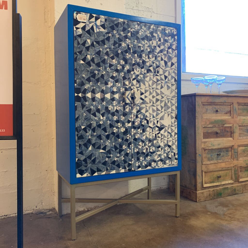 Cabinet with geometric patterned door in a room setting