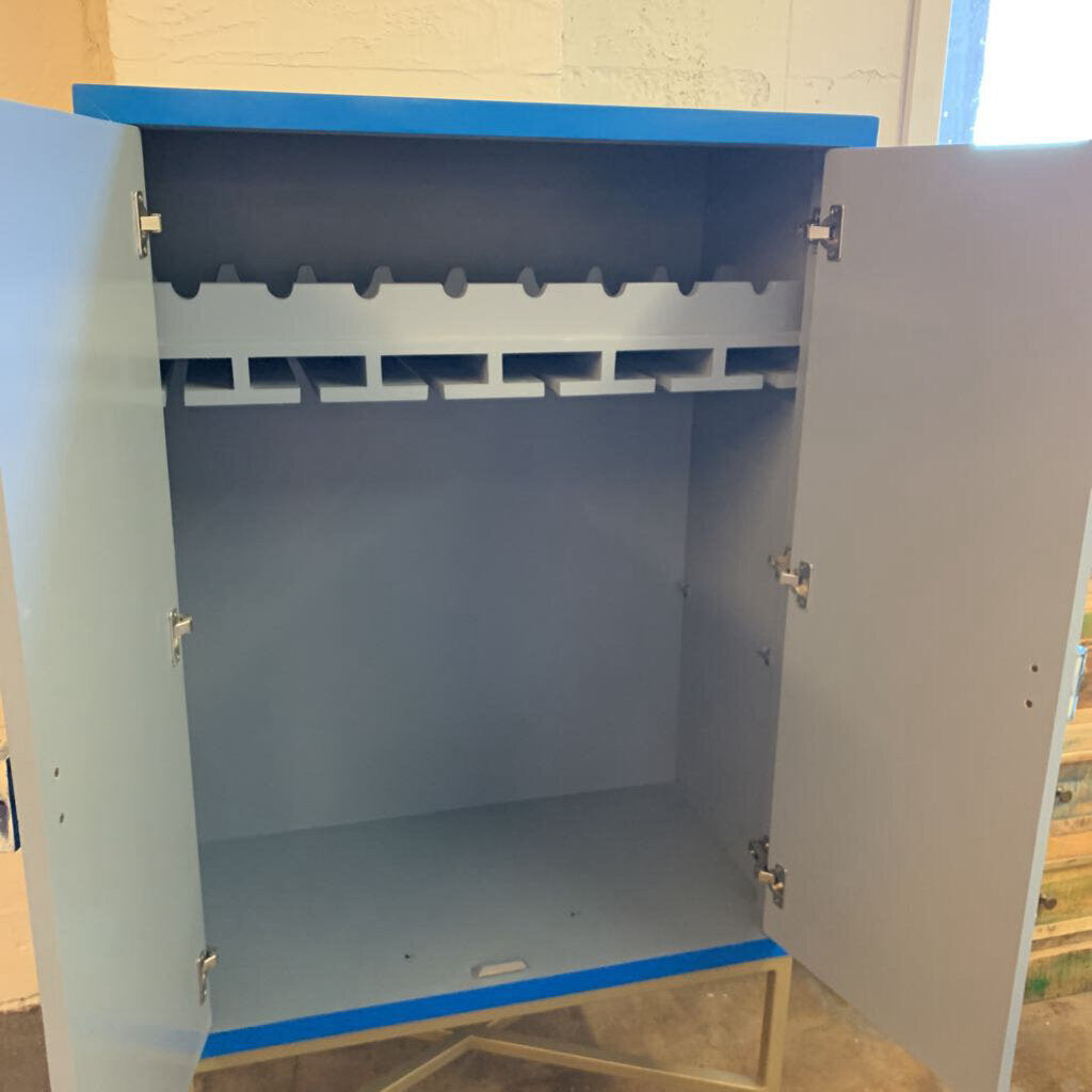 Metal cabinet with open doors showing interior shelves on a light-colored floor.