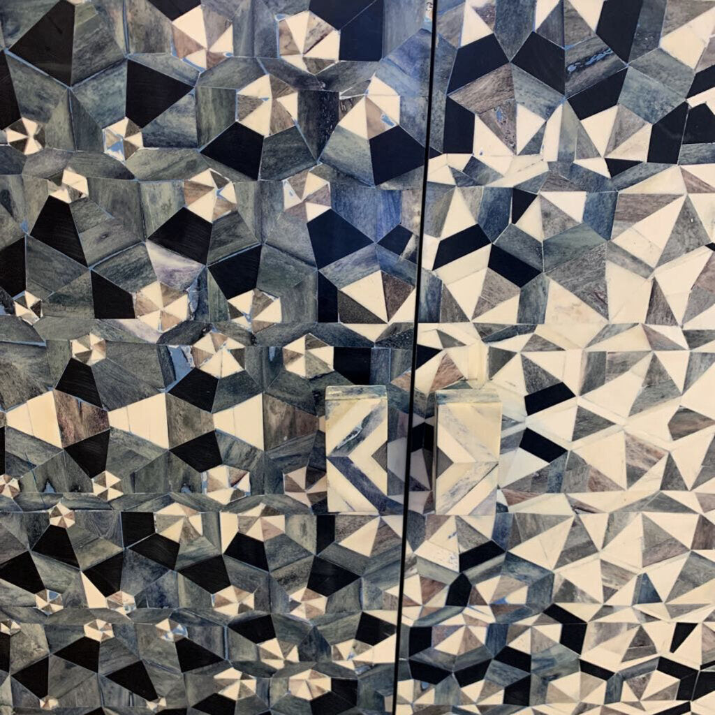 Geometric patterned fabric with a mix of blue, black, and beige colors.