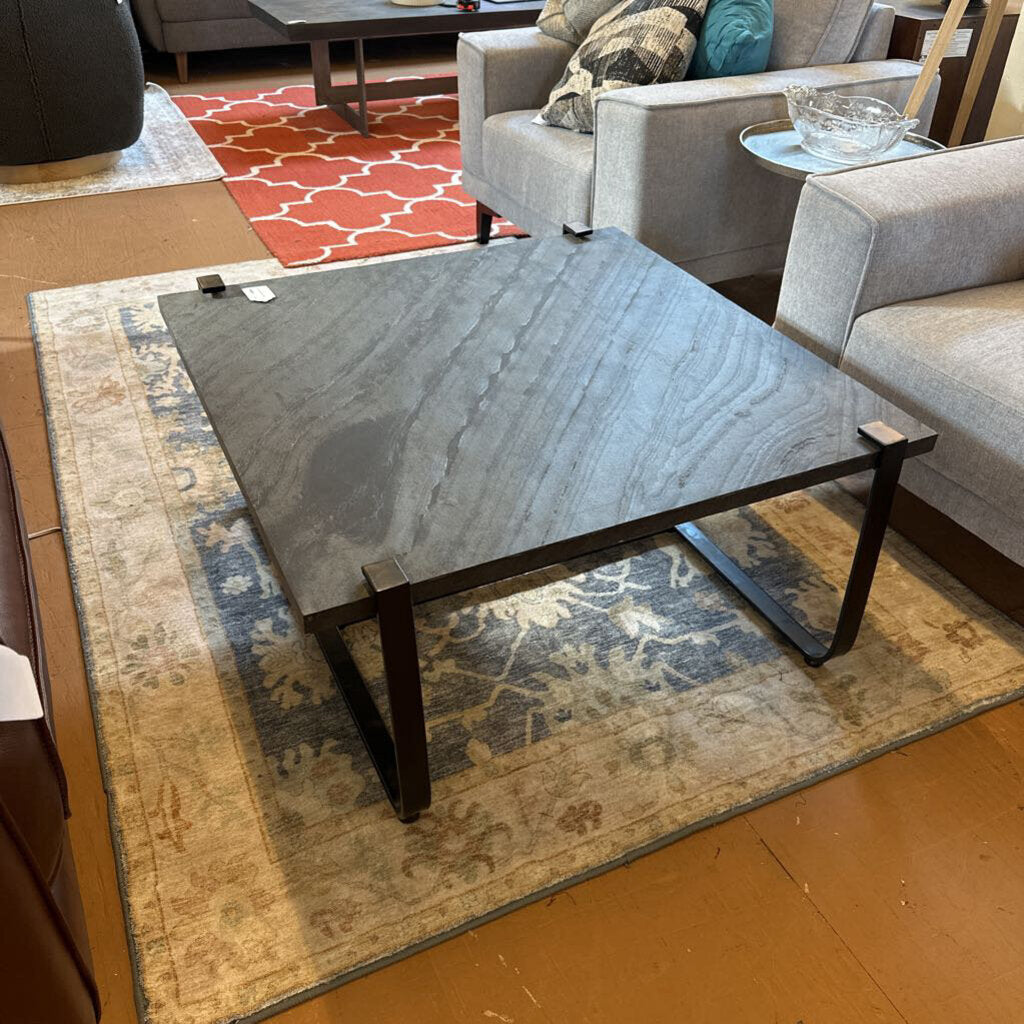 Coffee table in a living room setting with a rug and sofa