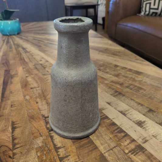 Concrete vase on a wooden floor with a blurred background