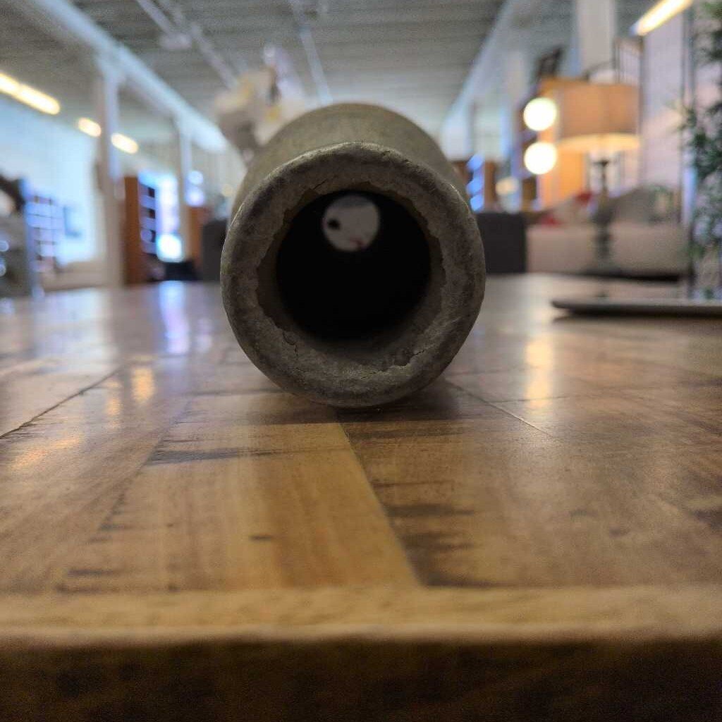 Cylindrical object on a wooden floor with a blurred indoor setting