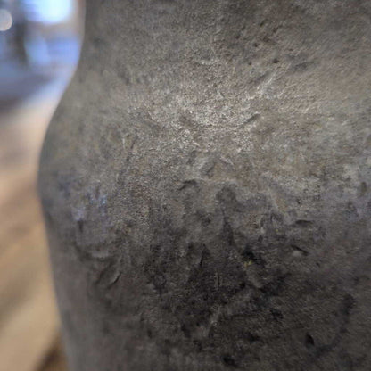 Close-up of a textured stone vase with a blurred background