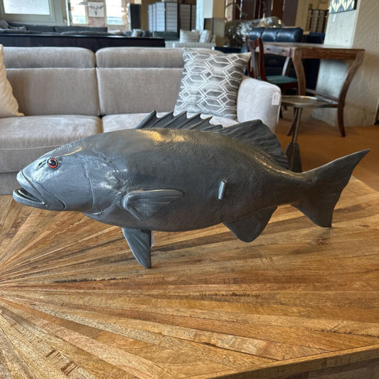 Large fish sculpture on a wooden table in a living room setting