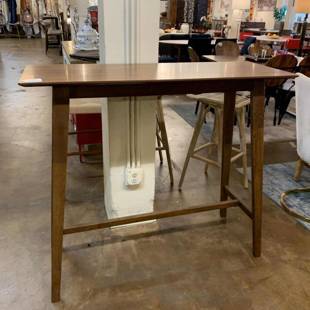 Wooden table in a store setting with various furniture items in the background