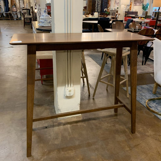 Wooden table in a store setting with various furniture items in the background