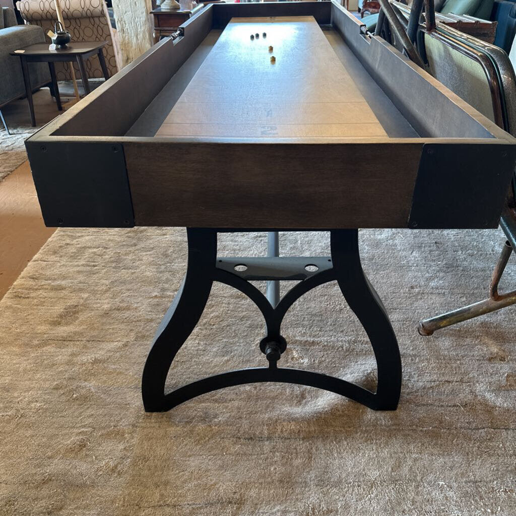 Wooden pool table with dark brown finish and black legs in a room setting.