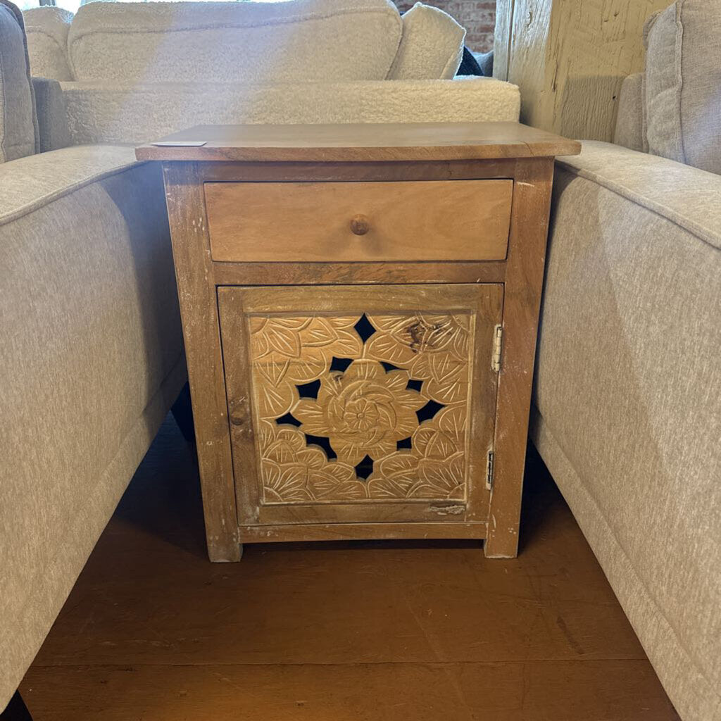 Wooden side table with decorative carvings in a living room setting