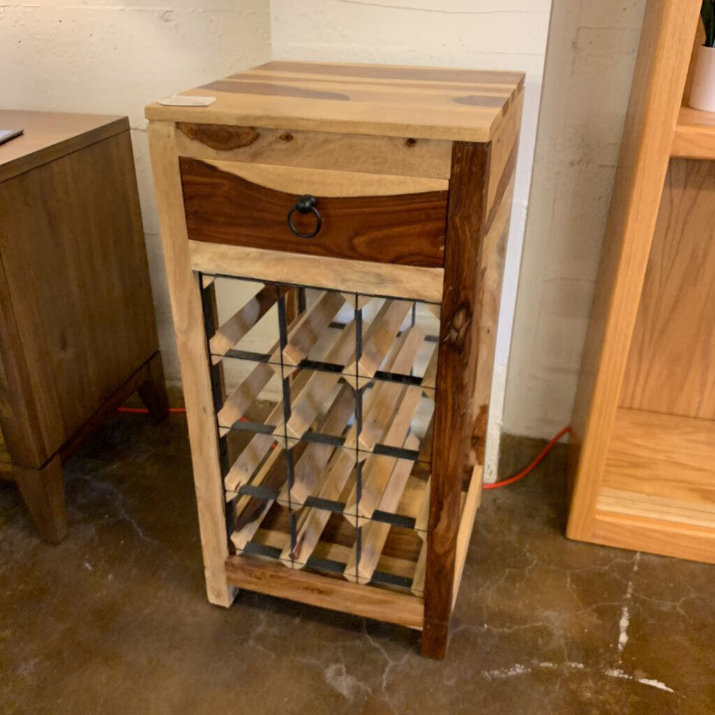 Wooden wine rack with a single drawer against a plain wall.
