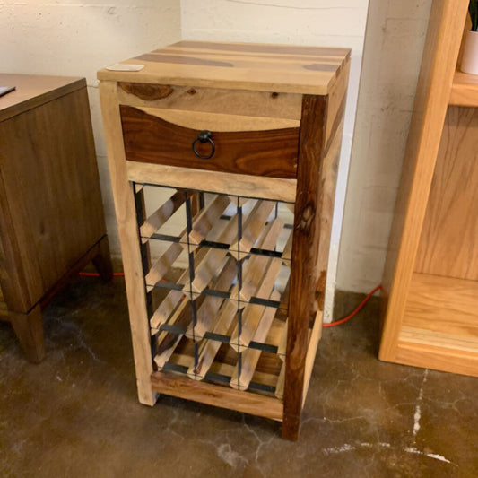Wooden wine rack with a single drawer against a plain wall.