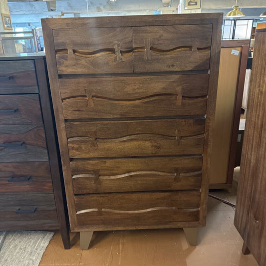 Wooden dresser with wavy drawer design in a store setting