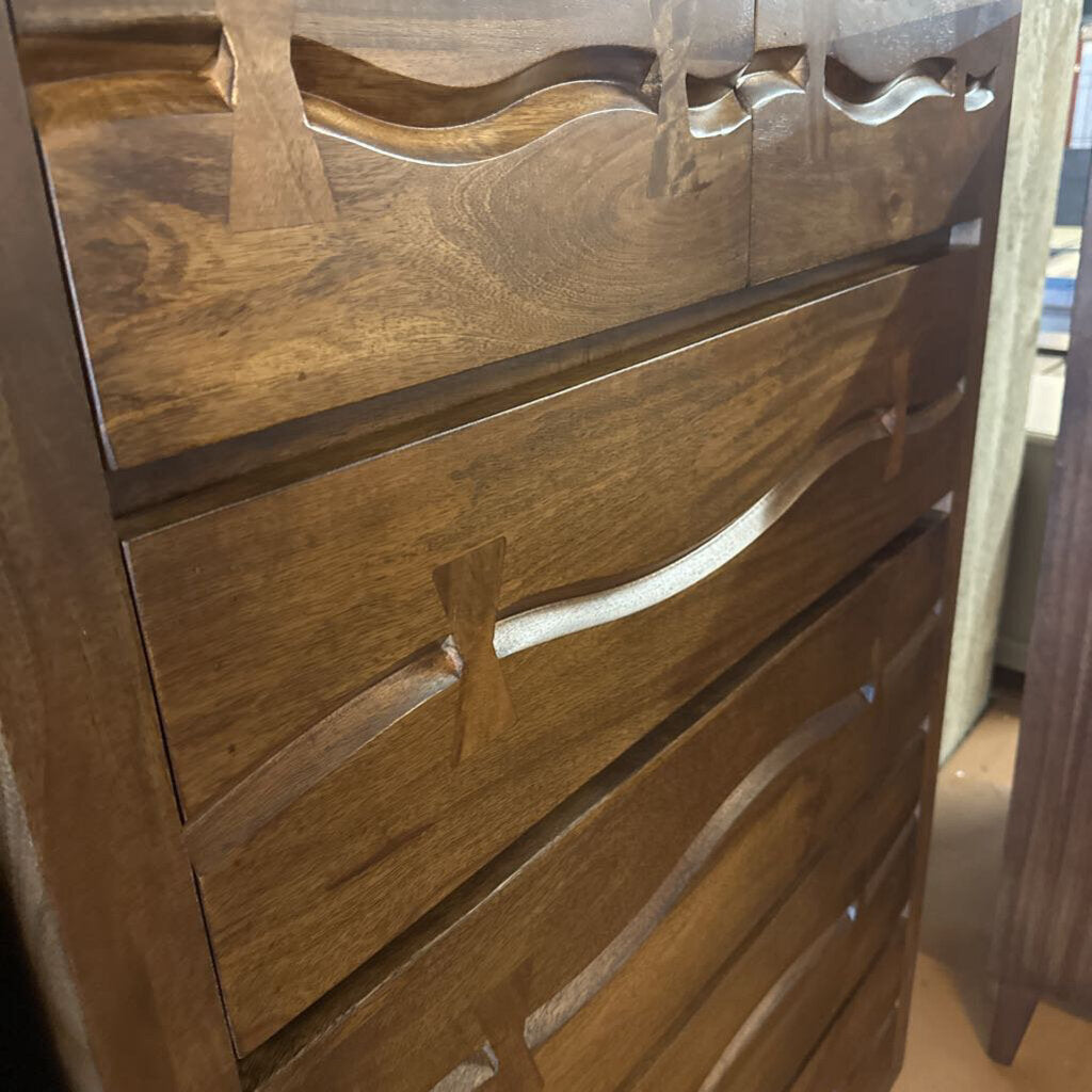 Wooden dresser with decorative carvings on a neutral background
