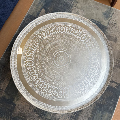 Decorative glass plate with intricate patterns on a textured surface