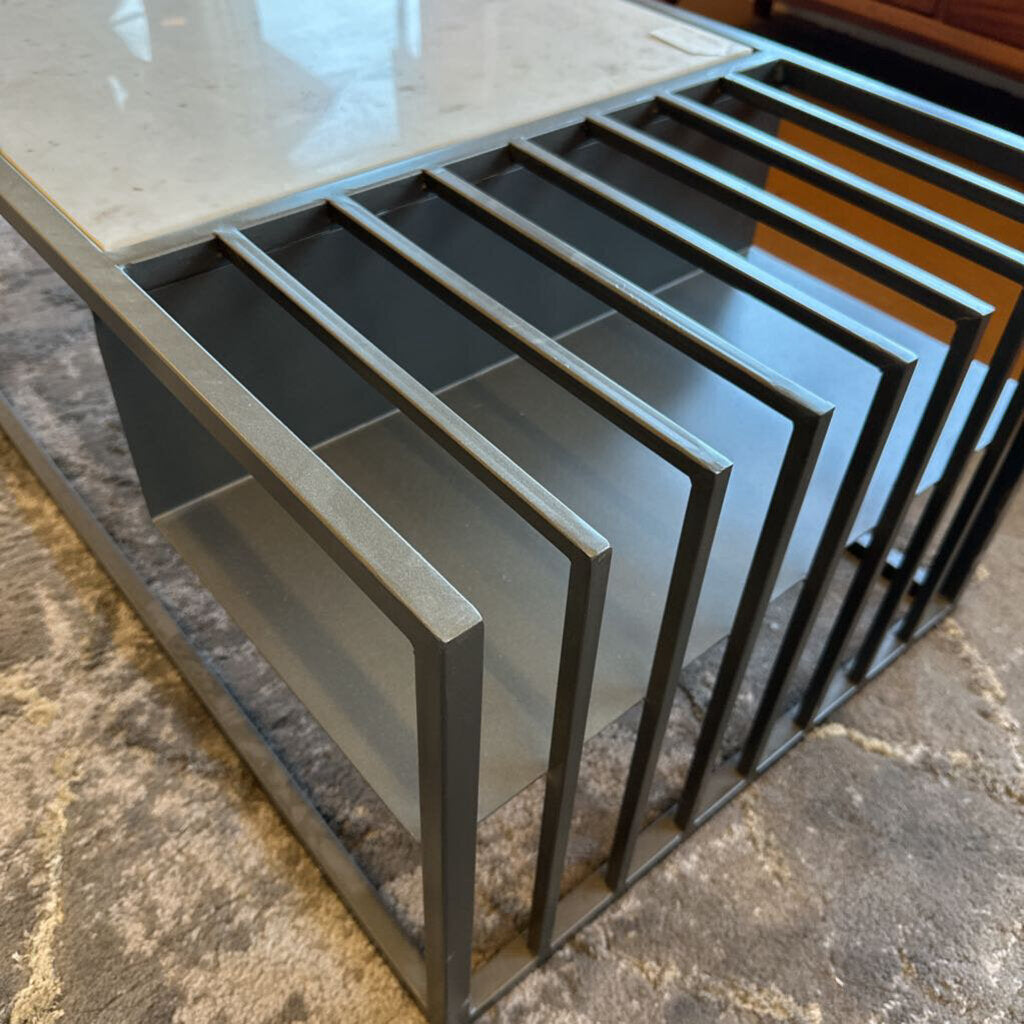 Coffee table with a marble top and metal frame on a stone floor