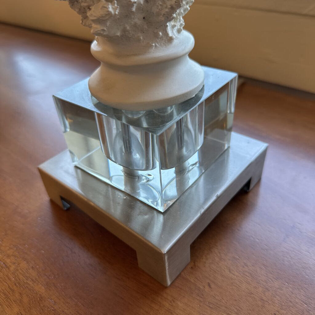 Decorative object with a white base and crystal-like structure on a wooden surface