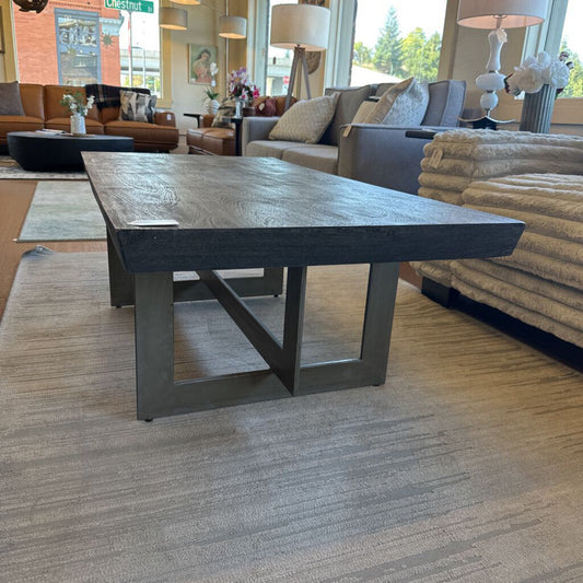 Wooden coffee table in a living room setting with furniture and decor.