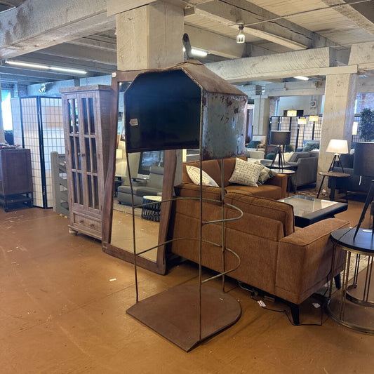 Futuristic metallic sculpture in a showroom with furniture in the background