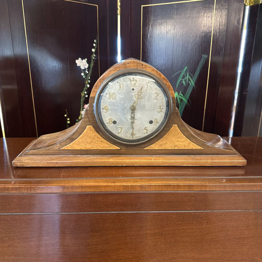 Wooden clock on a wooden surface with a dark background