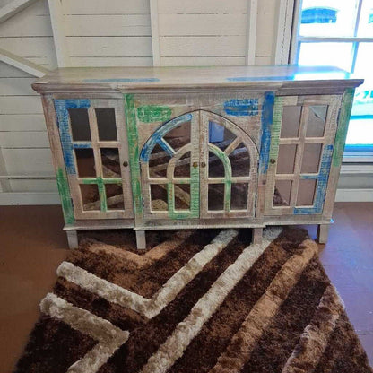 Wooden cabinet with decorative glass panels on a brown rug