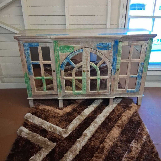 Wooden cabinet with decorative glass panels on a brown rug