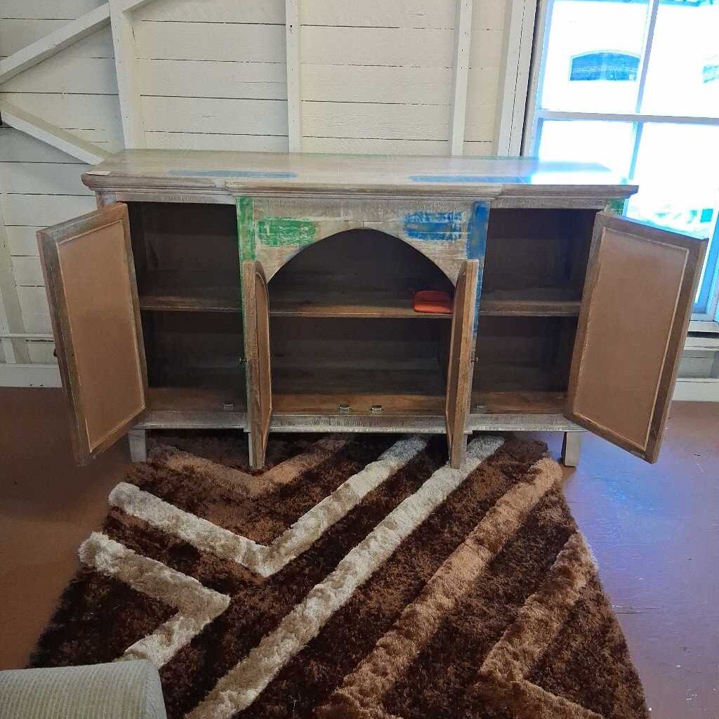 Wooden cabinet with open doors on a patterned rug
