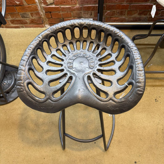 Cast iron decorative element on a stand with a brick wall background