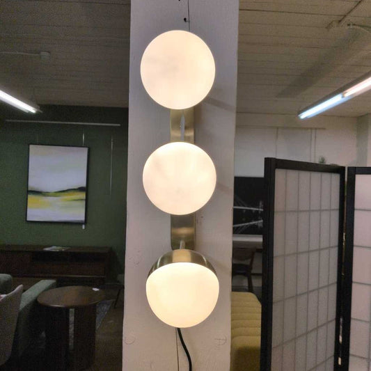 Three spherical lights hanging from a ceiling in an indoor setting.