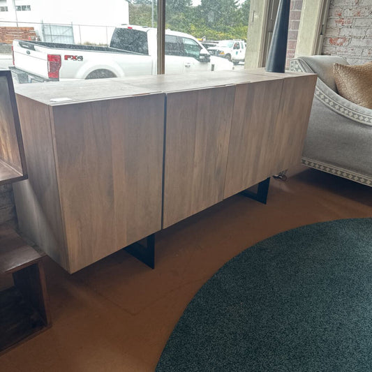 Wooden sideboard in a room with a rug and window view
