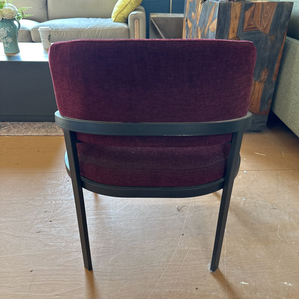 Chair with purple cushioned backrest and seat in a room setting.